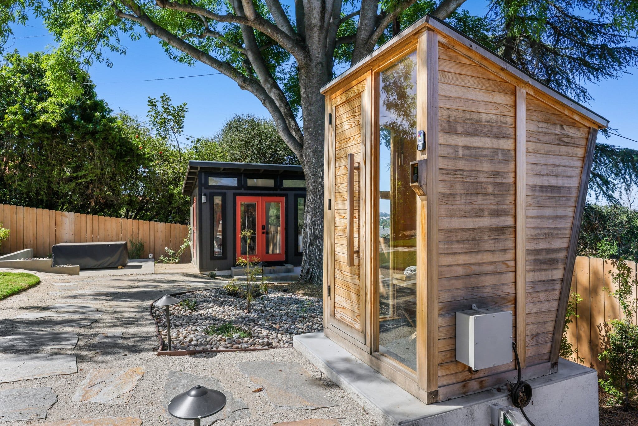 cedar-clad backyard sauna and detached studio under a mature tree