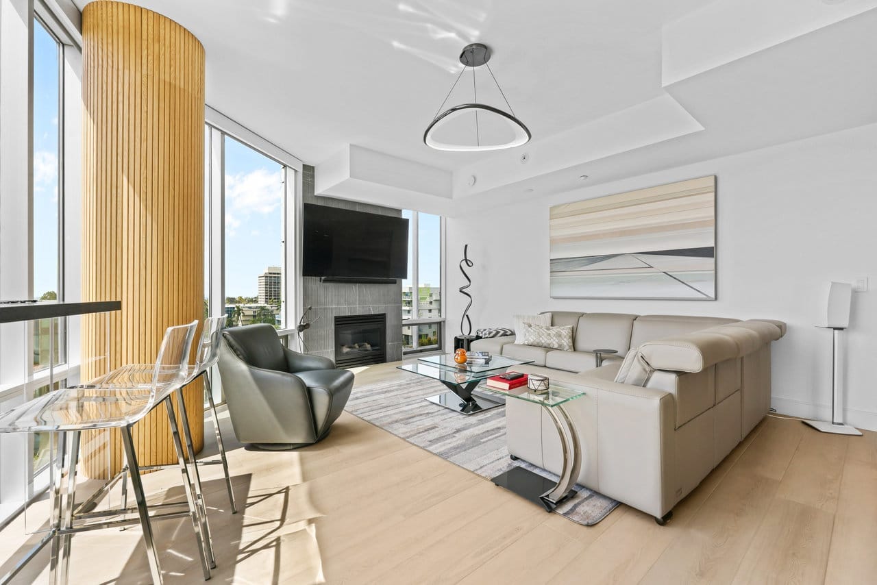 Bright living room with leather sectional, fireplace and curved wood column