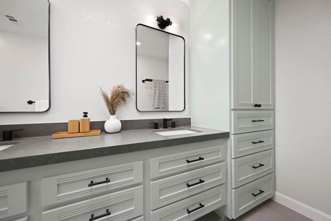 Sage vanity with quartz top, fluted drawer fronts, and matching linen tower
