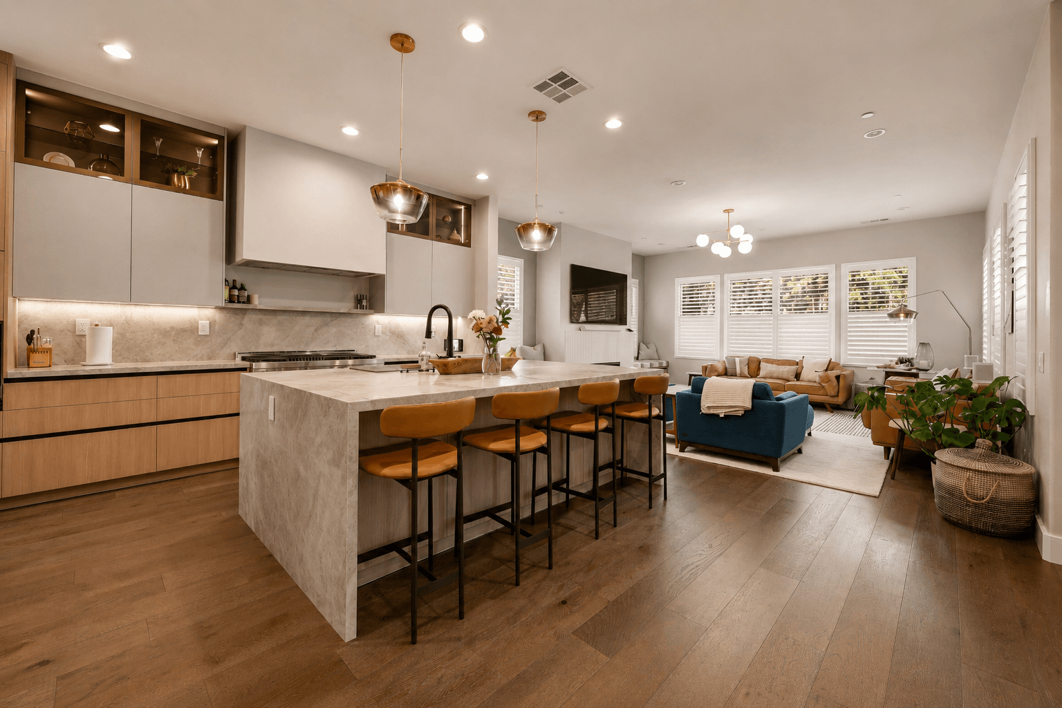 Open-concept kitchen with waterfall island, leather barstools and adjoining living room