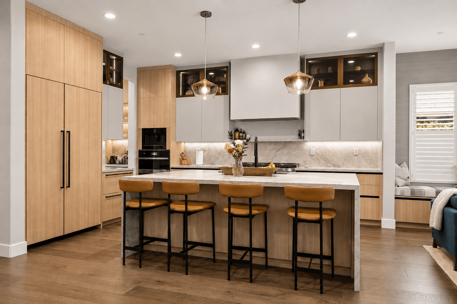 Open kitchen with two-tone cabinets, waterfall island and pendant lighting