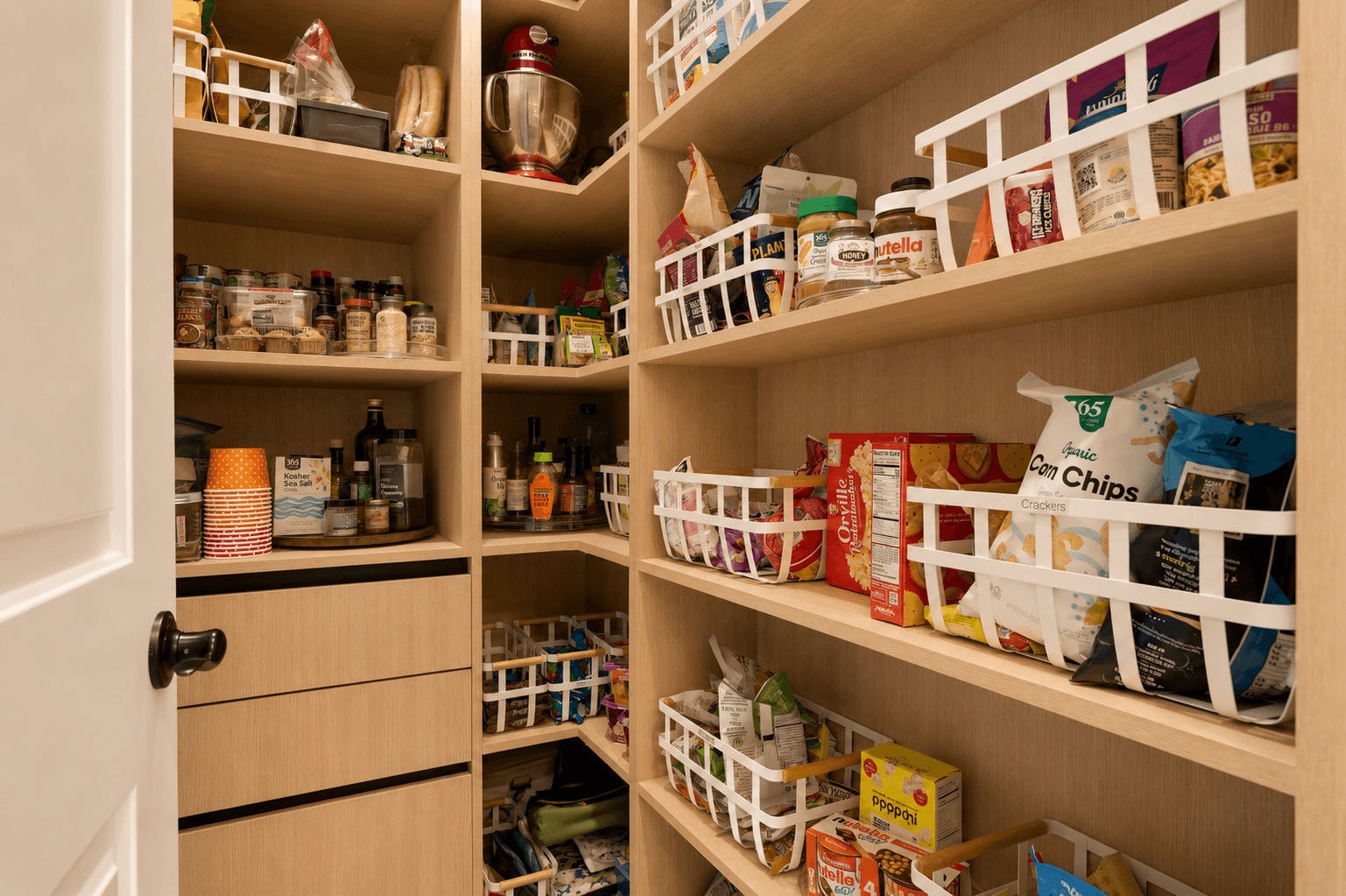 Walk-in pantry with oak shelving and organized white storage bins