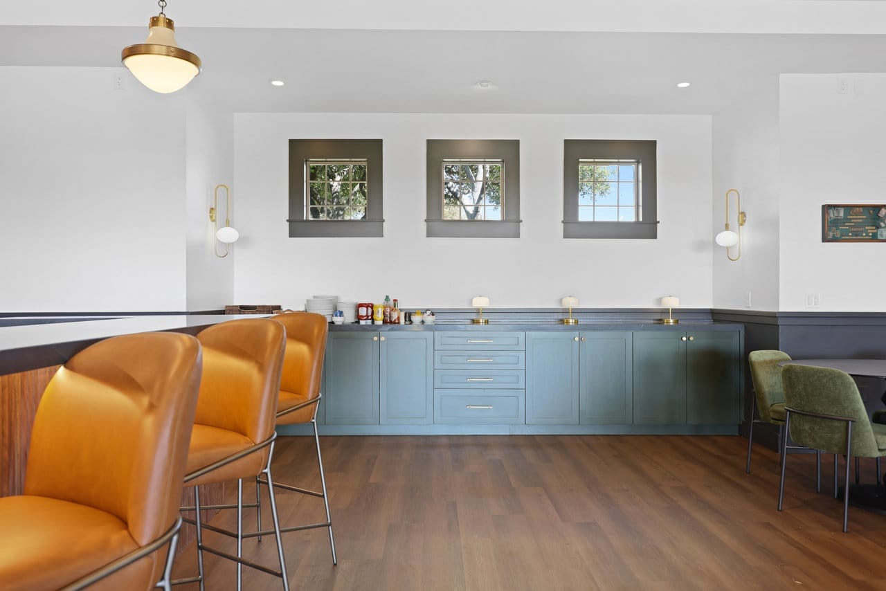 Service station with teal shaker cabinets, gray stone counter and arched windows