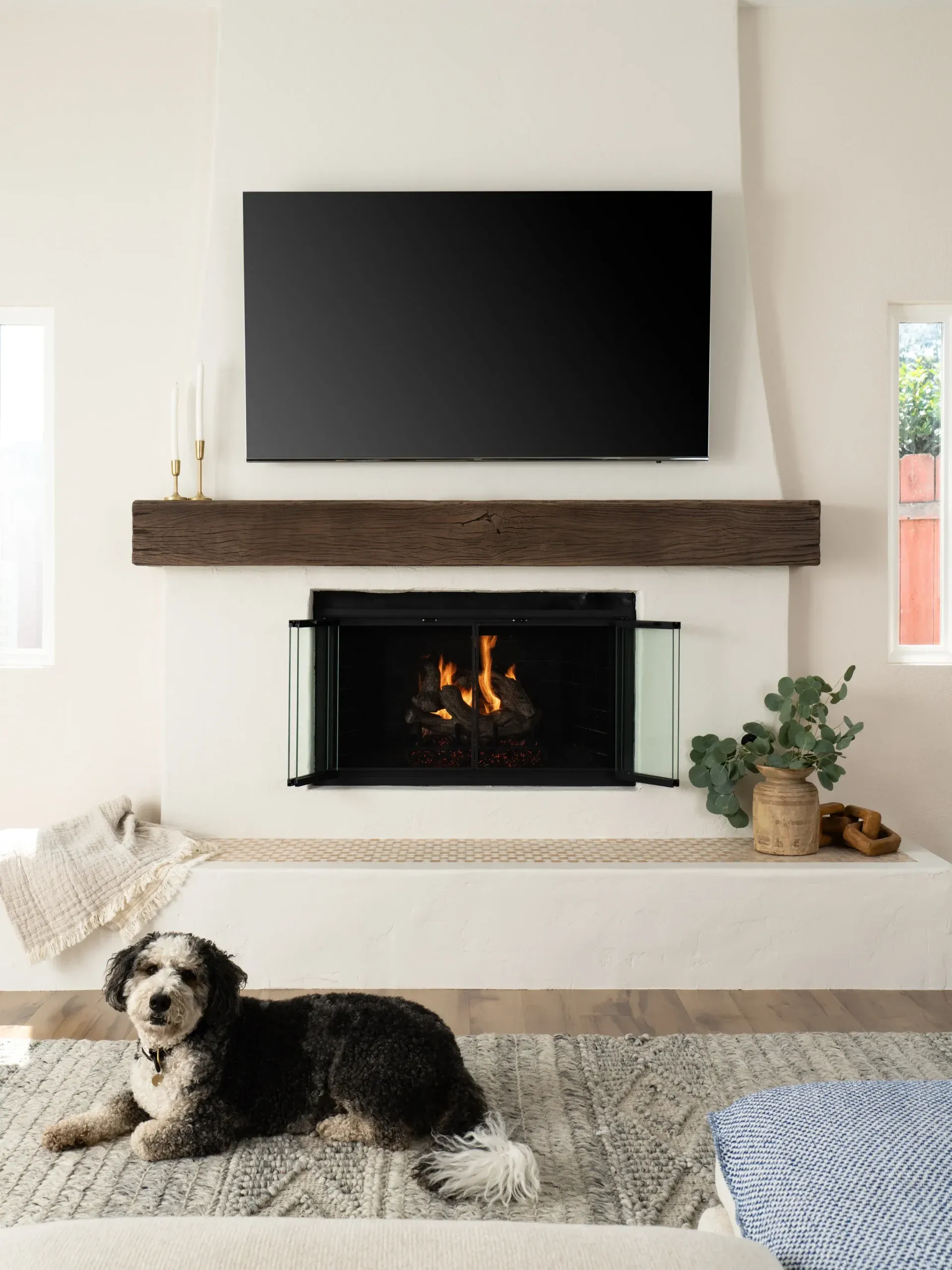 Cozy living room with stone fireplace, wood mantel, and mounted television