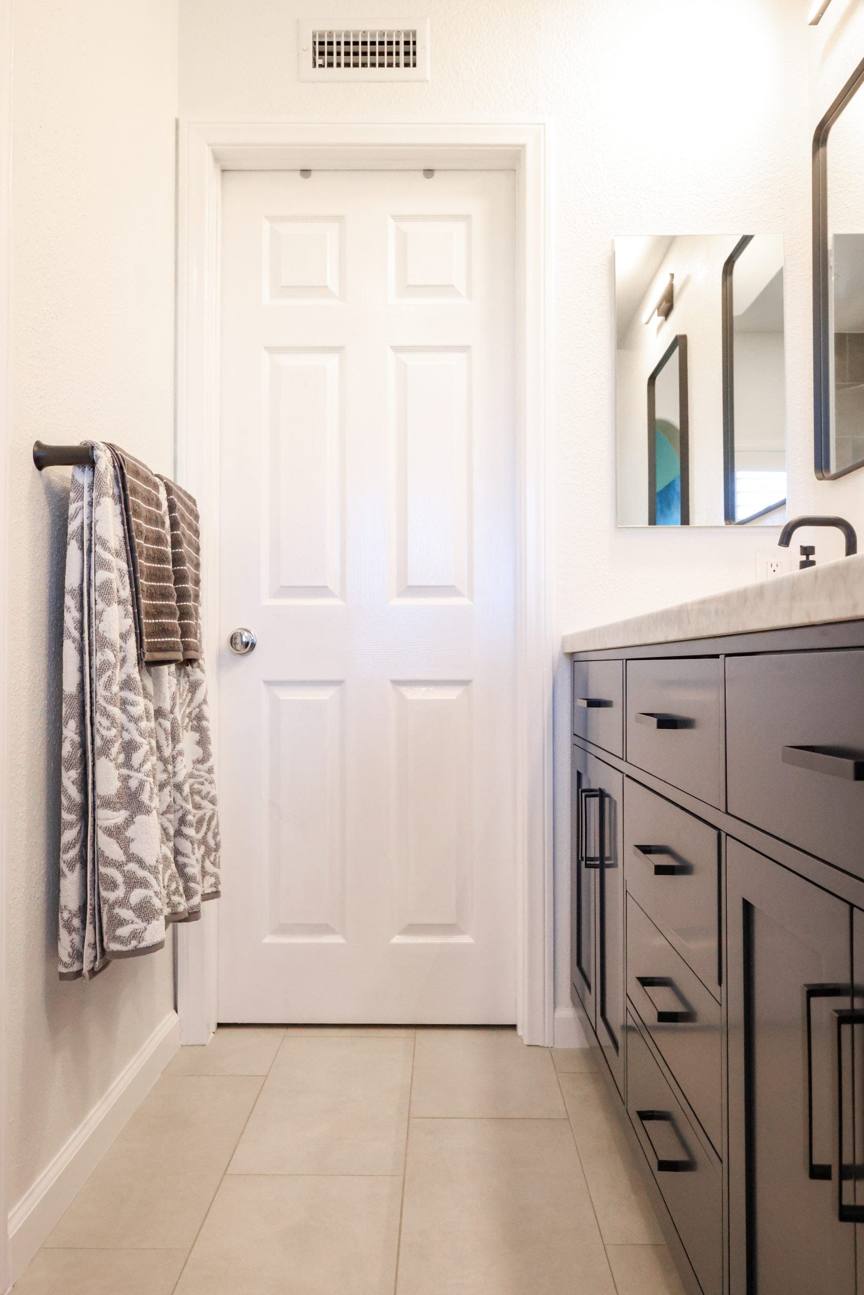 Bathroom with navy shaker vanity, marble top and white paneled door