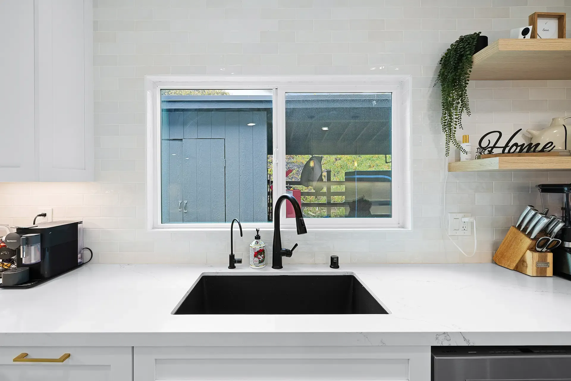 Black undermount sink and faucet against white subway tile backsplash