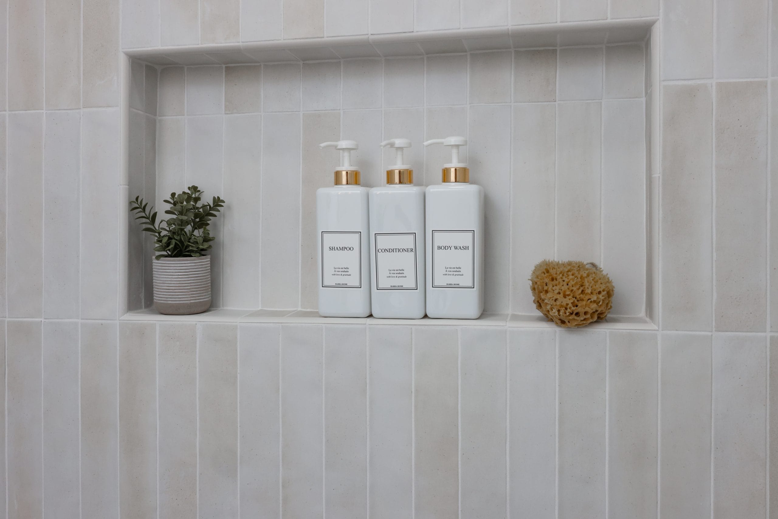 close-up of recessed shower niche on cream stacked tile holding bath bottles