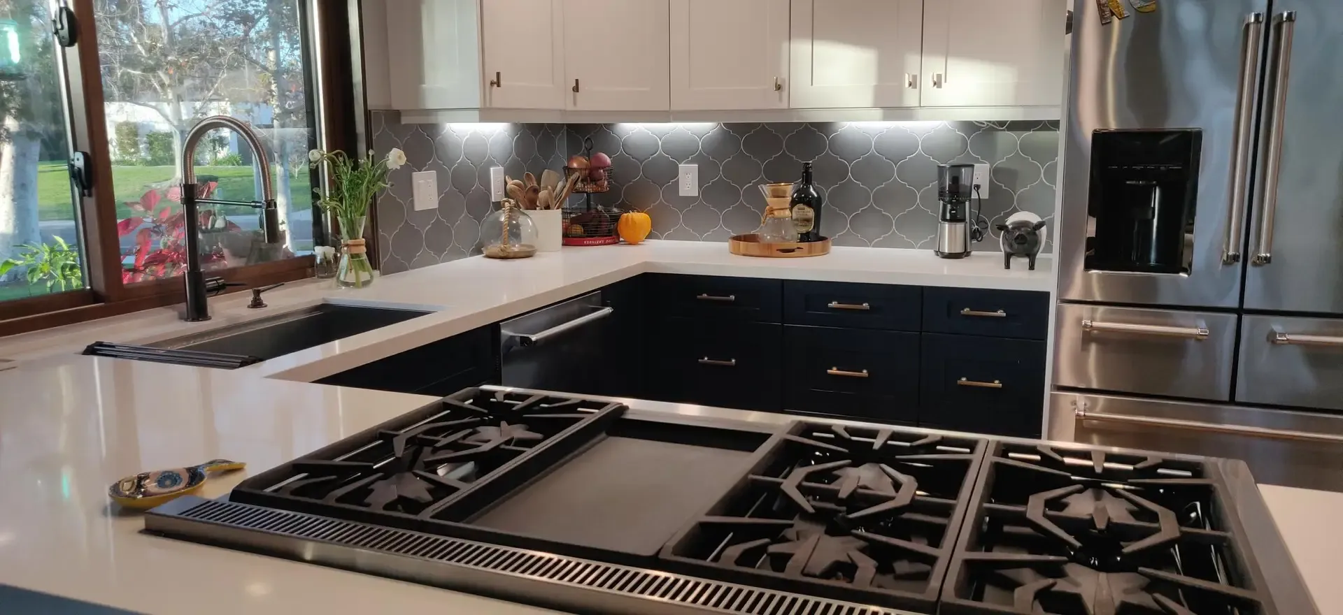 Contemporary kitchen with black gas cooktop island and tiled backsplash
