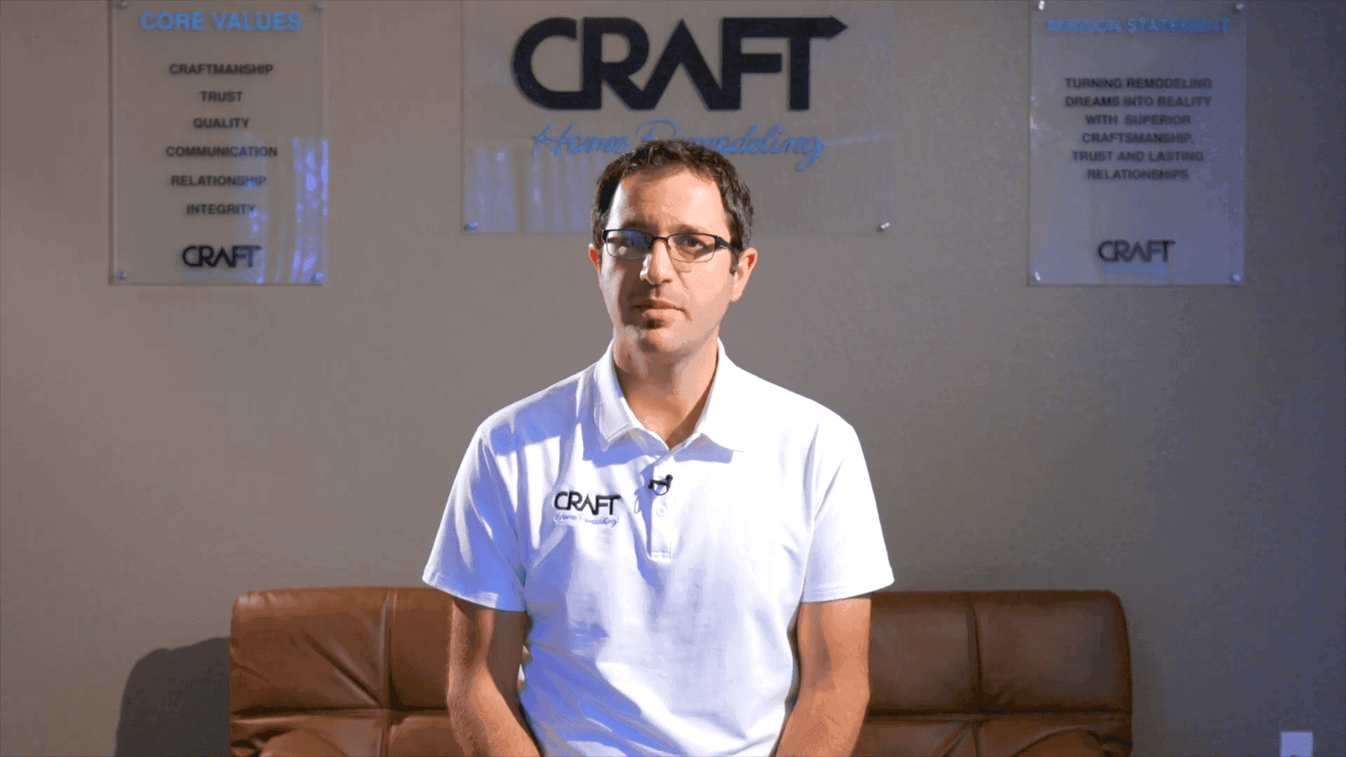 Craft Home Remodeling team member speaking on camera in front of the company core-values display