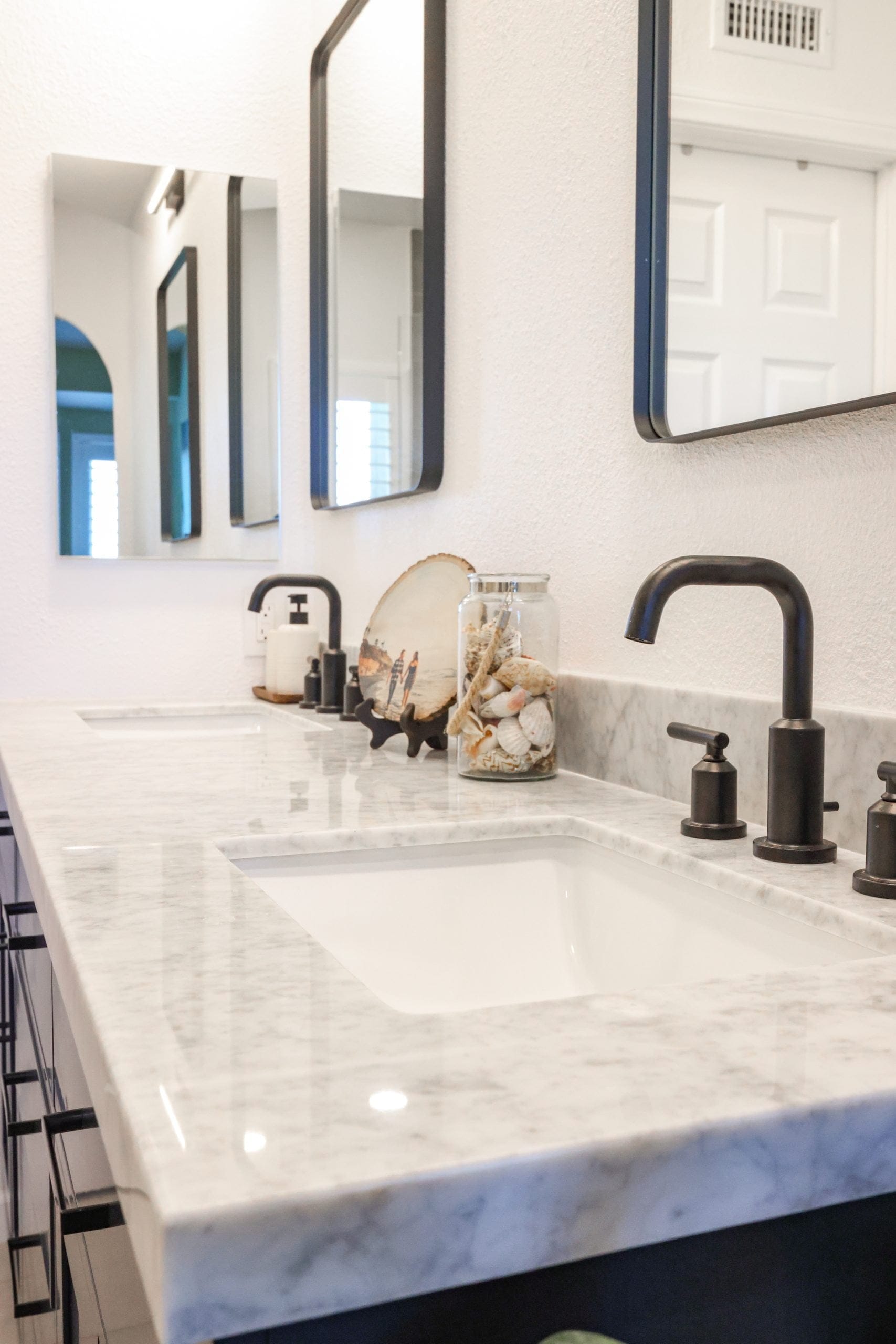 Double vanity with Carrara marble countertop, undermount sinks and matte black faucets