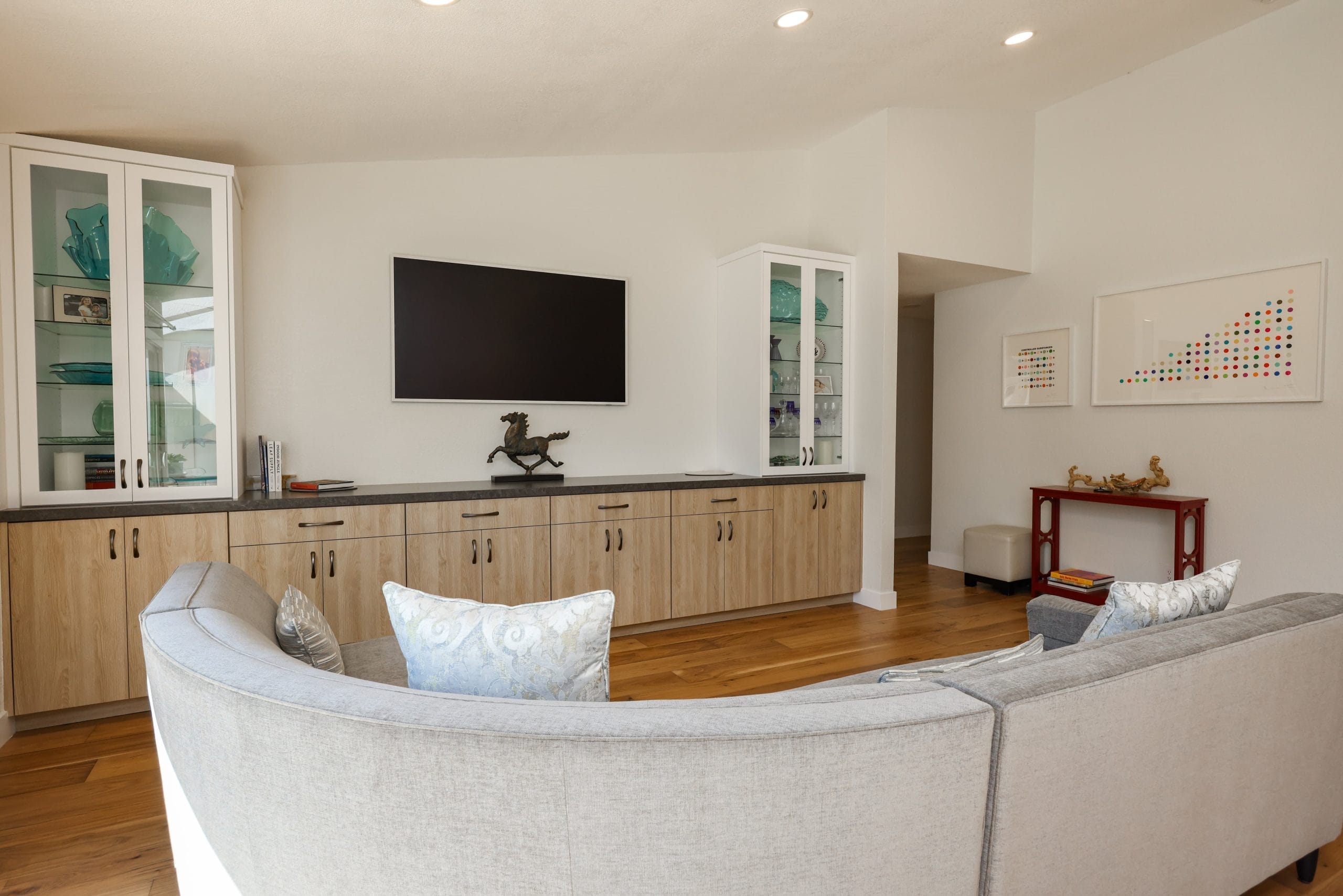 Family room with built-in glass display cabinets and wall-mounted television