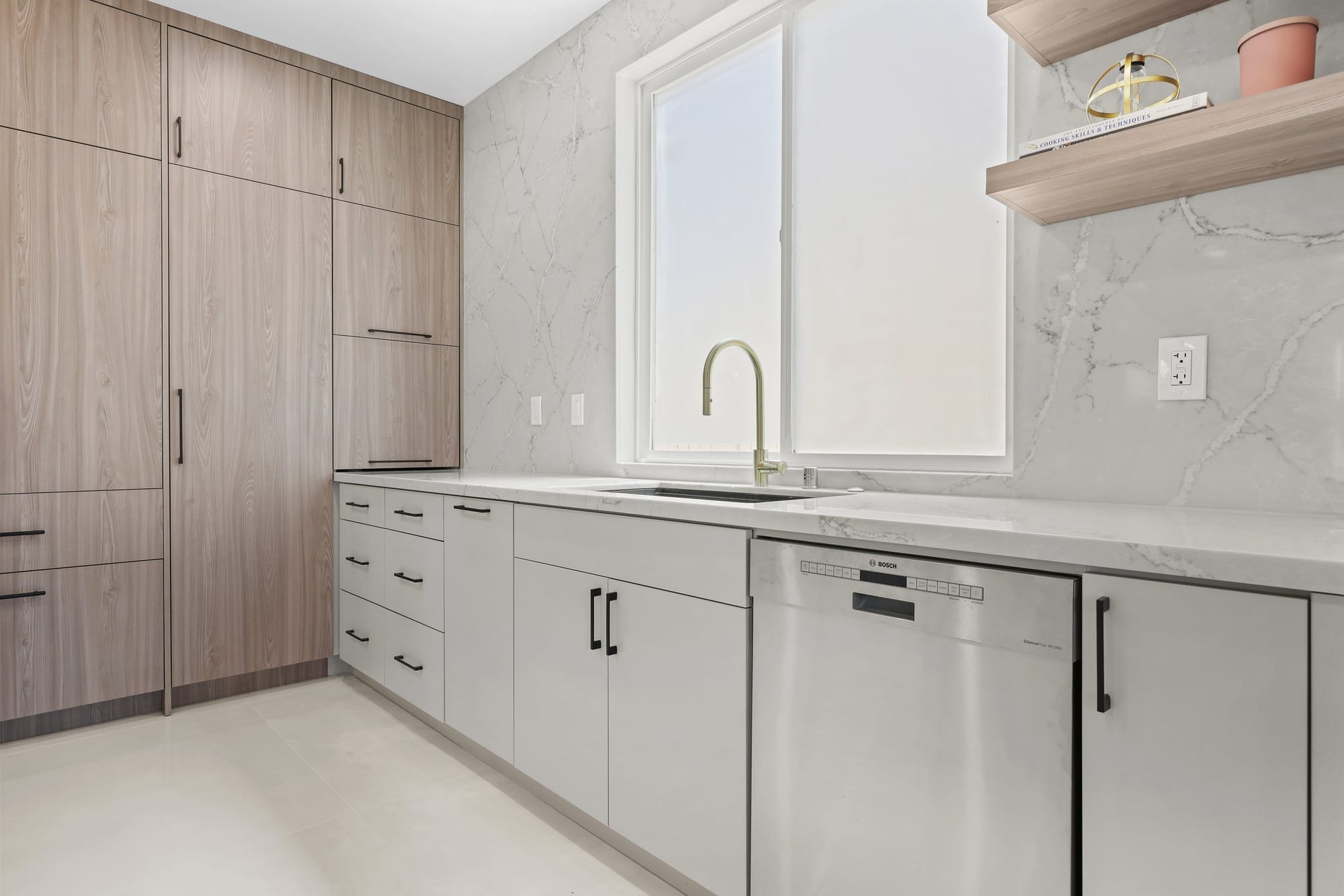 Galley kitchen with wood cabinets, marble backsplash and stainless Bosch dishwasher