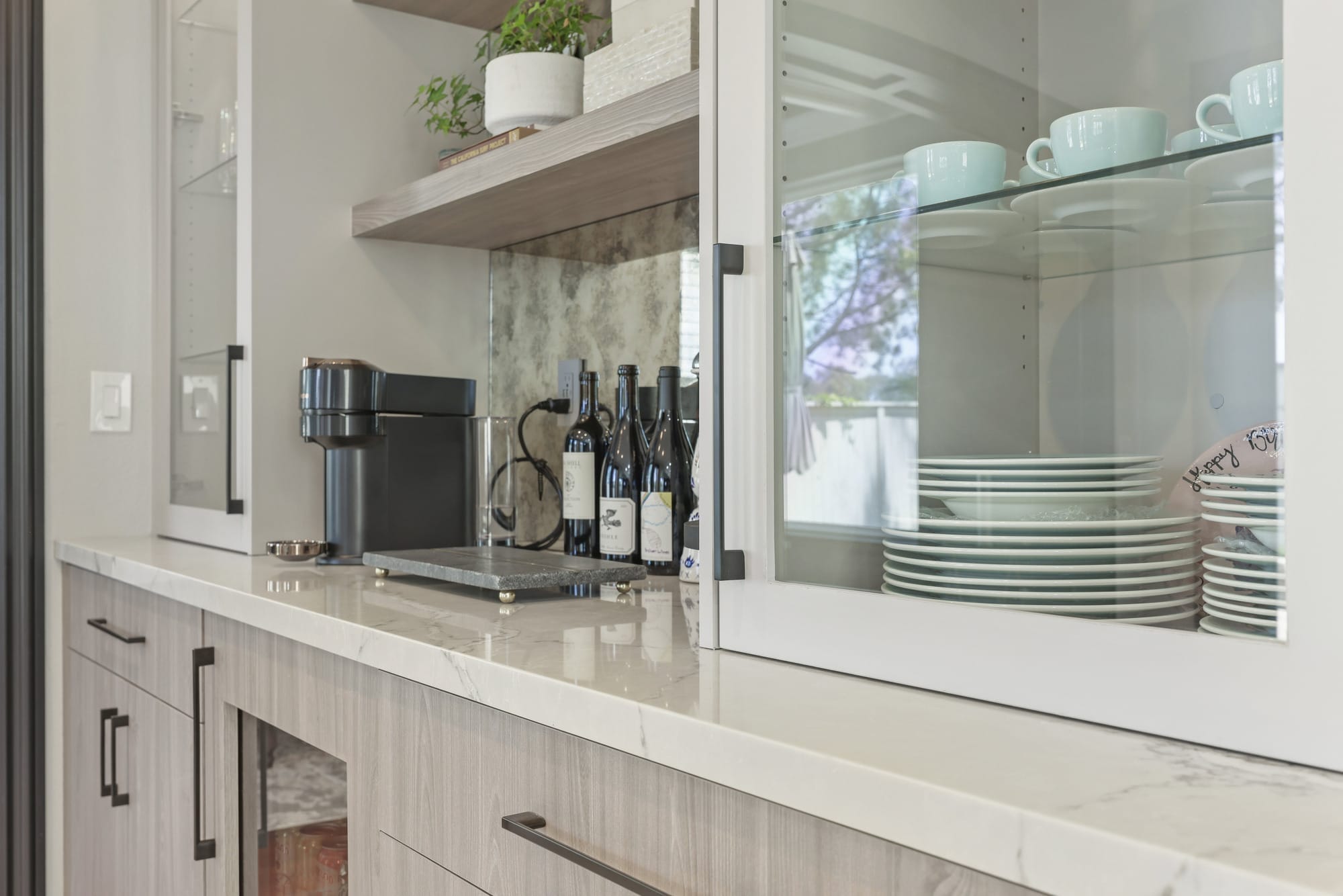 Quartz bar counter with espresso machine, floating shelf and glass dishware cabinet
