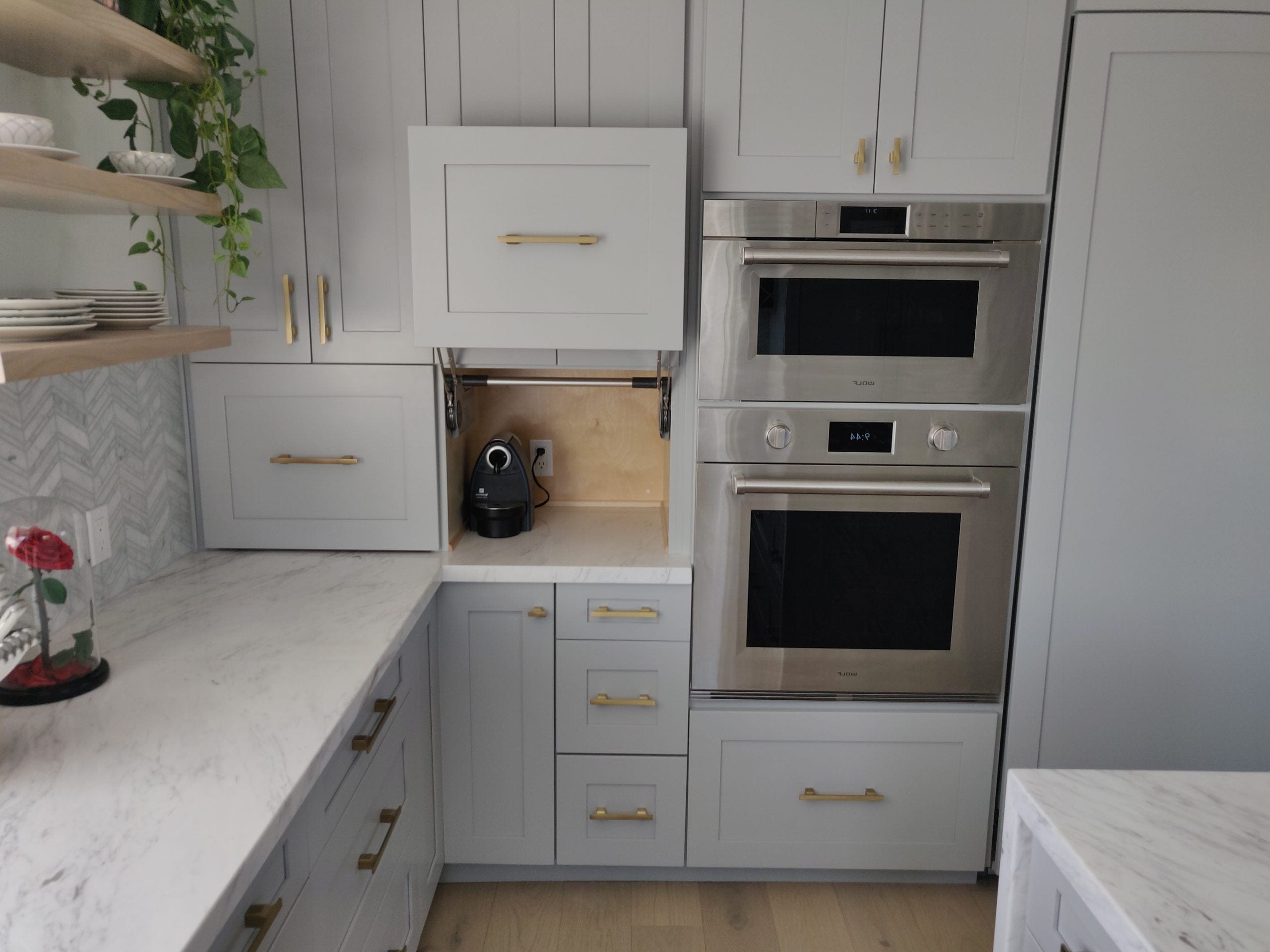 gray kitchen corner with appliance garage, double wall ovens, and marble counters