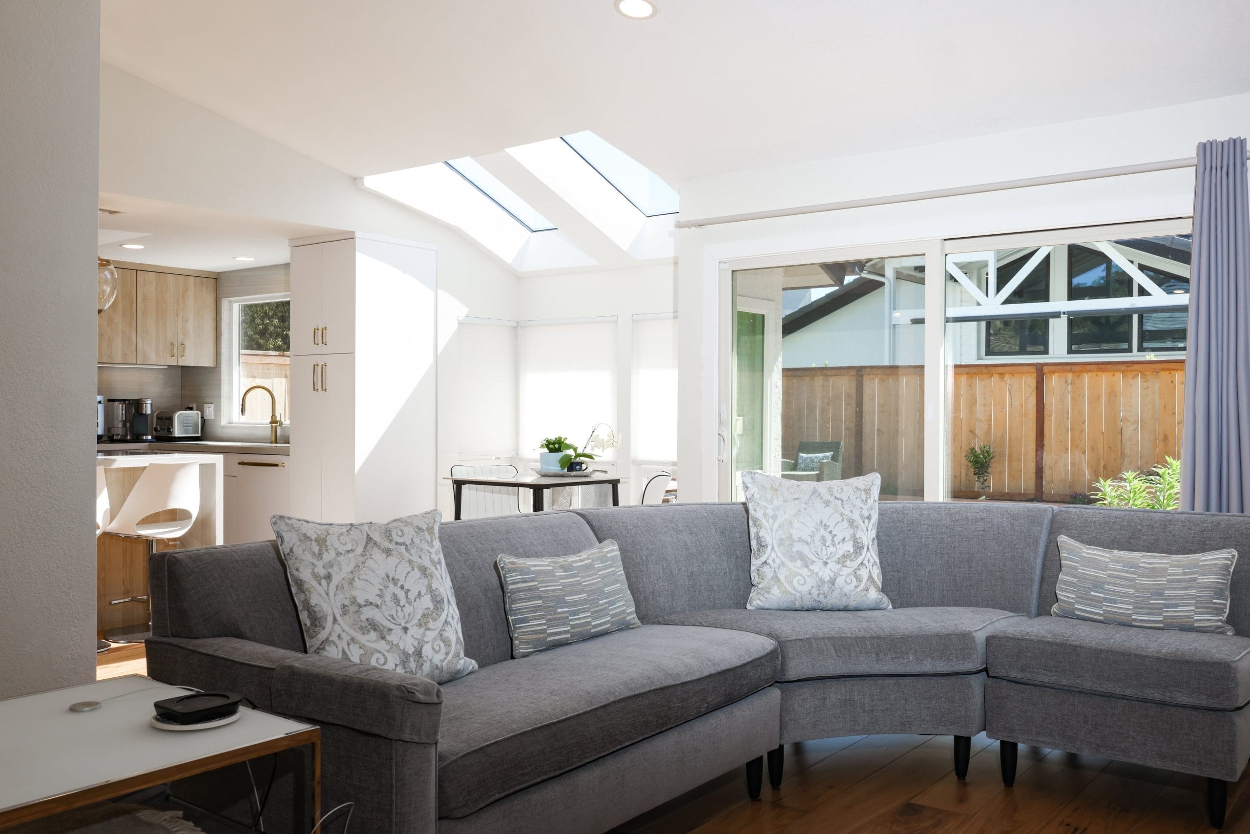 Great room sectional under vaulted skylight ceiling open to the kitchen