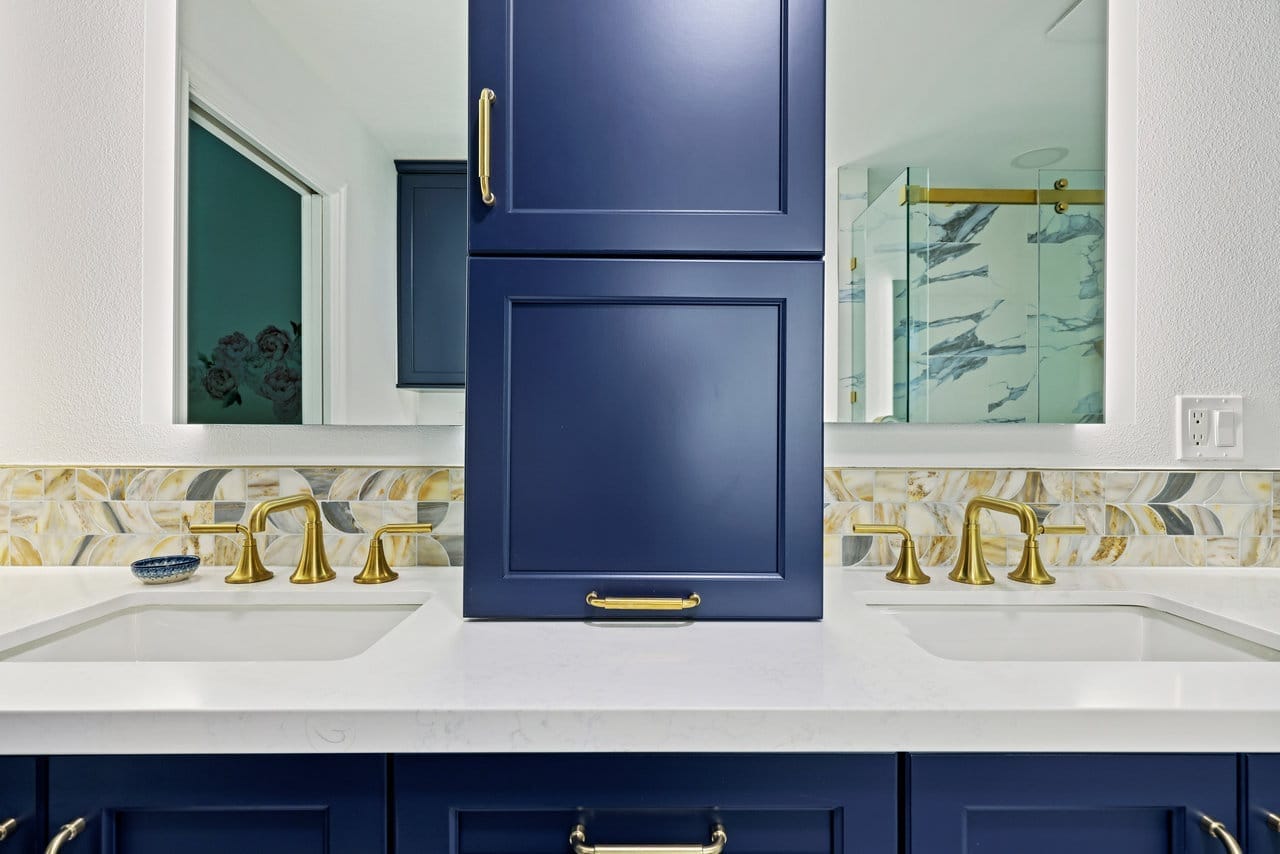 his-and-hers navy vanity with twin undermount sinks, gold faucets and central storage tower