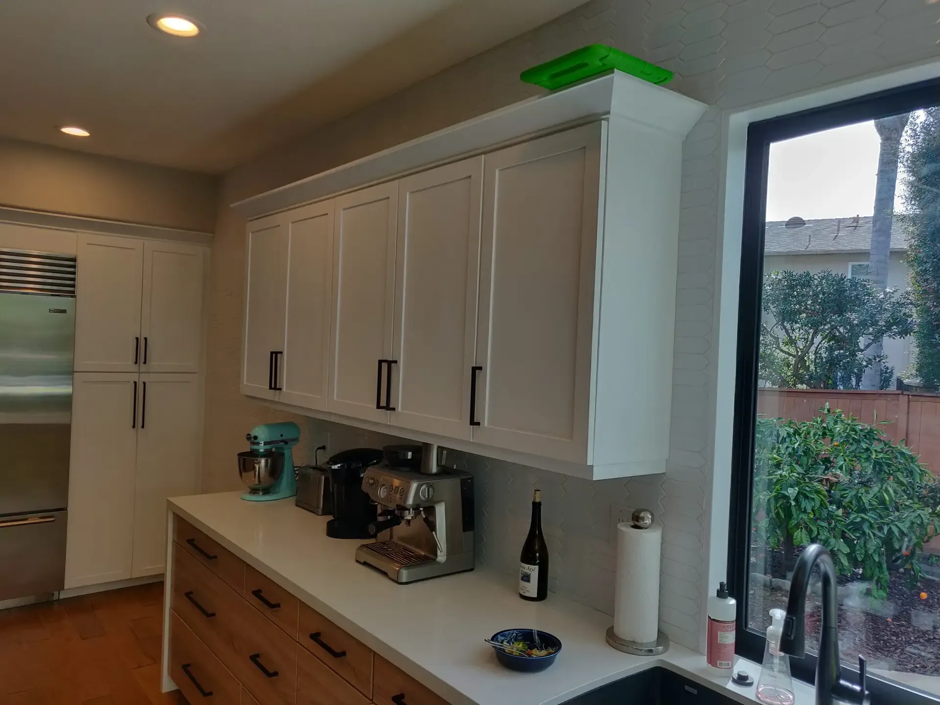 Kitchen coffee station with white uppers, quartz counter and tile backsplash