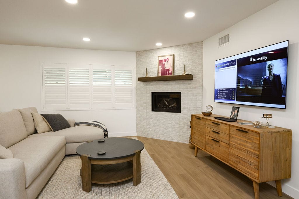Living room with sectional sofa, stacked-stone fireplace and walnut media console
