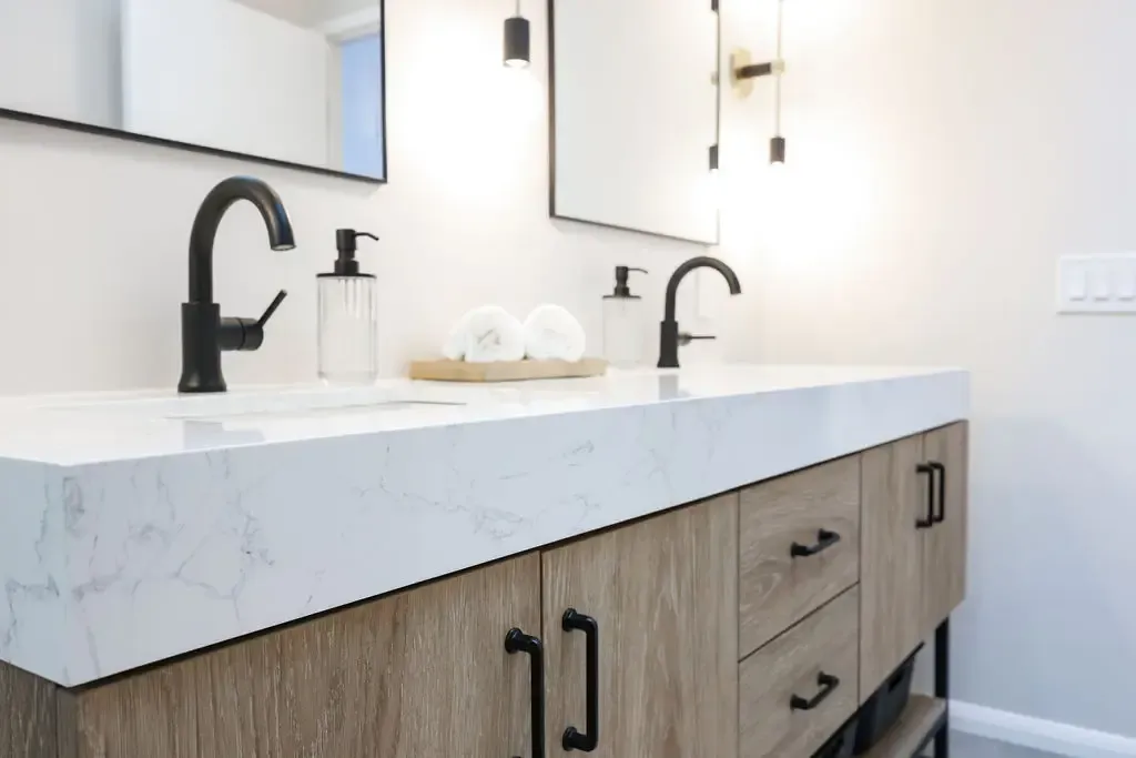 Modern double vanity with waterfall quartz counter and warm wood cabinetry