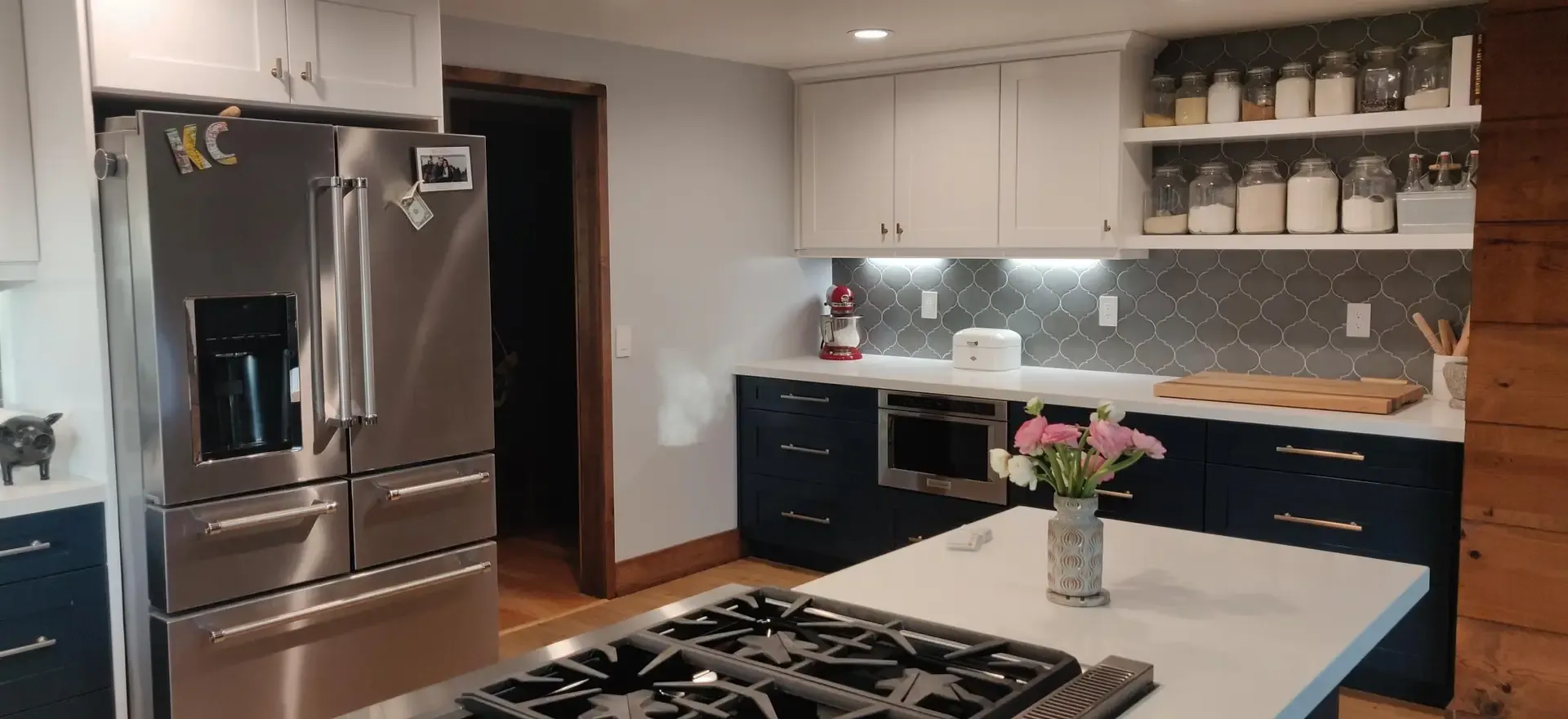 Modern kitchen with navy lower cabinets, white uppers and stainless French-door refrigerator