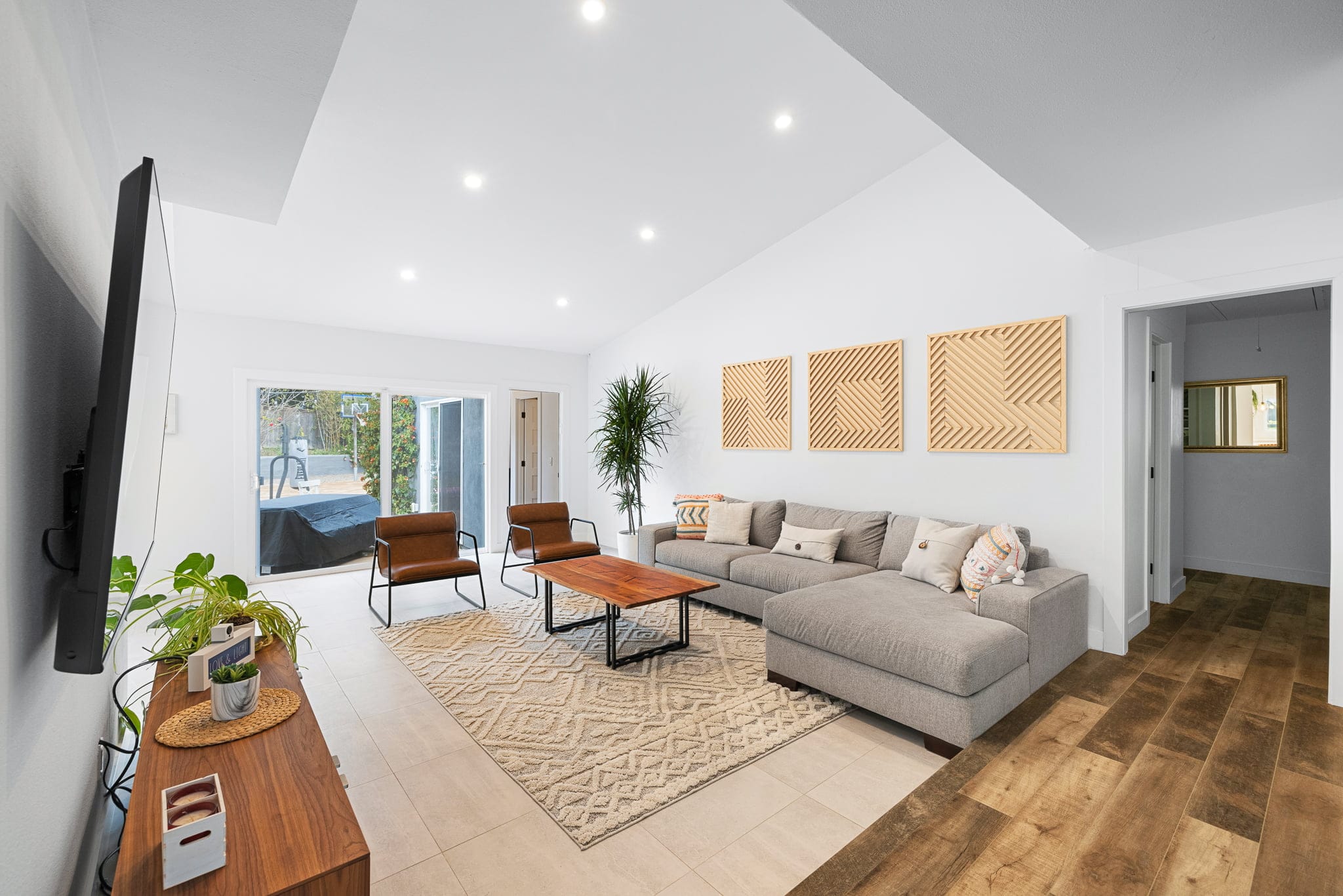 Modern living room featuring leather chairs, wood coffee table and patterned area rug