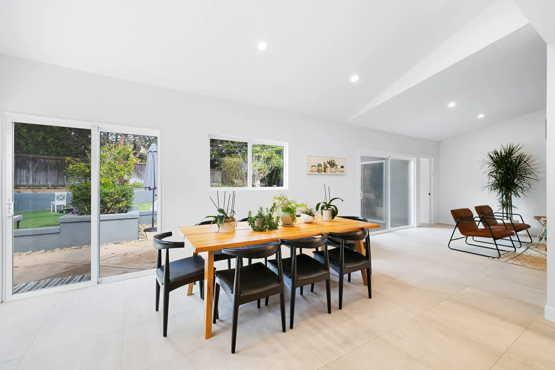 open-concept dining room with vaulted ceiling, wood table, and large sliding glass doors