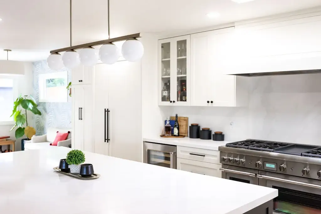 Open kitchen with quartz island, glass-globe pendants and pro range
