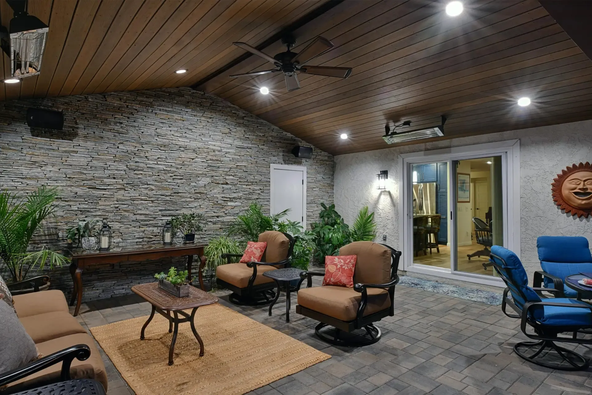 Outdoor living area under wood ceiling with stacked stone walls and seating