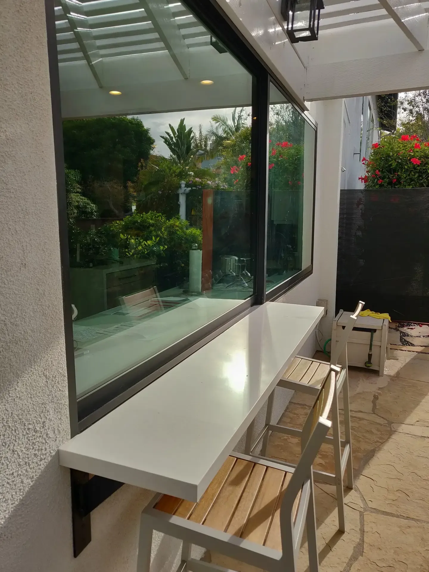 Pass-through window counter with bar stools opening to a flagstone garden patio