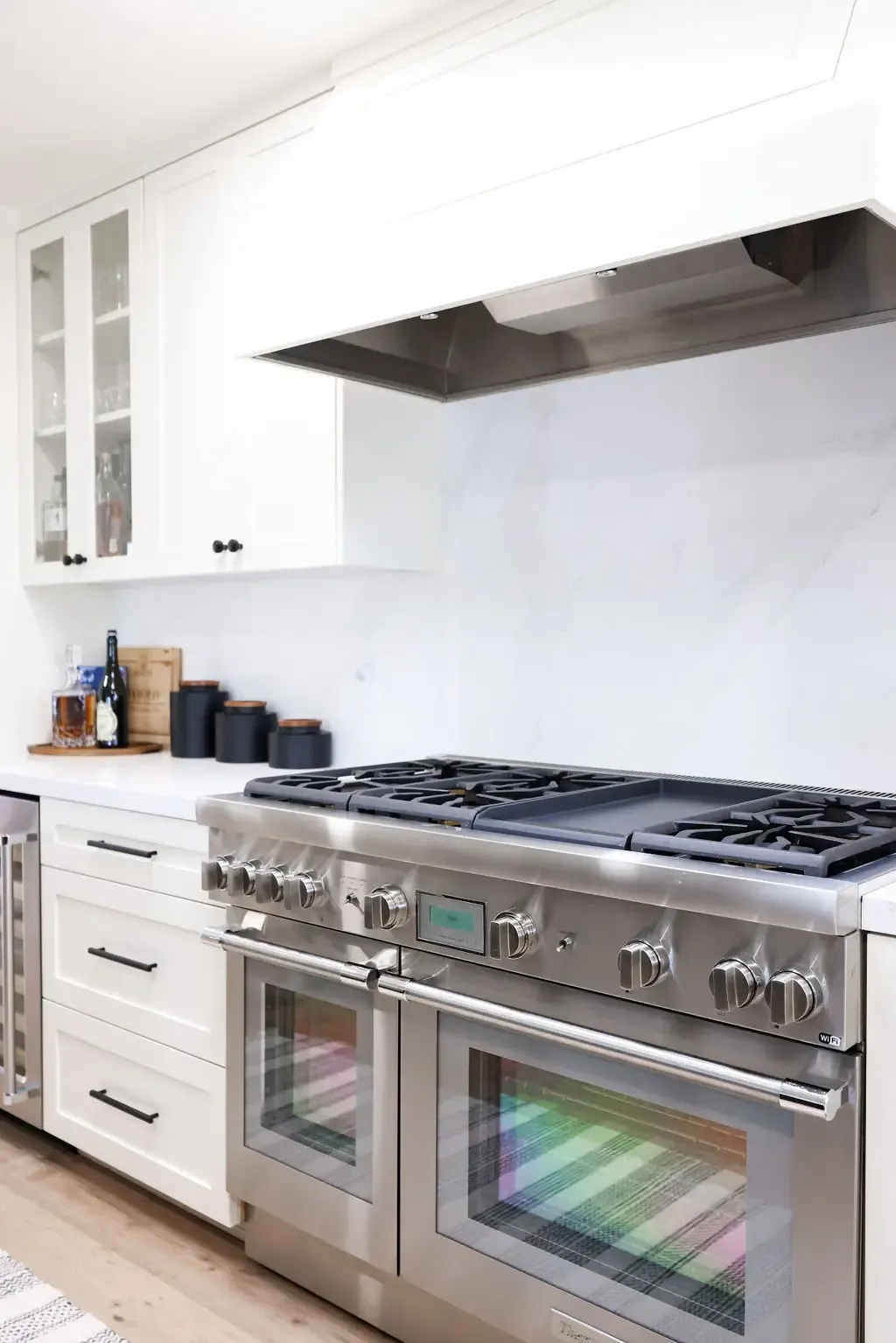 Pro stainless double-oven range under sleek vent hood in white kitchen