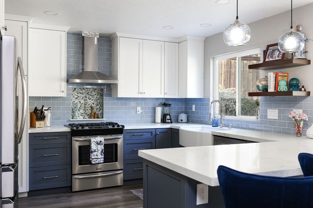 Remodeled kitchen featuring navy base cabinets, farmhouse sink and blue tile backsplash