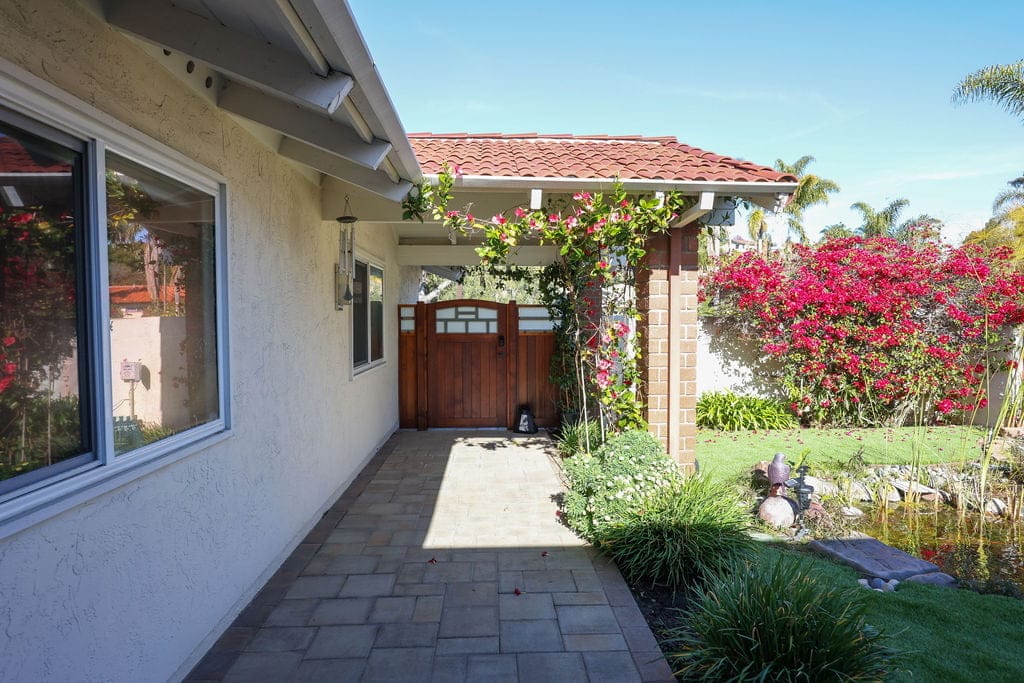 Side yard walkway with paver path, tile roof and blooming bougainvillea