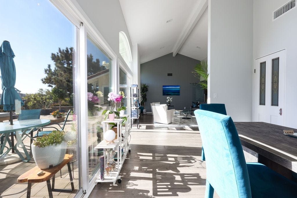 Sliding glass doors connecting dining area to sunny patio and garden