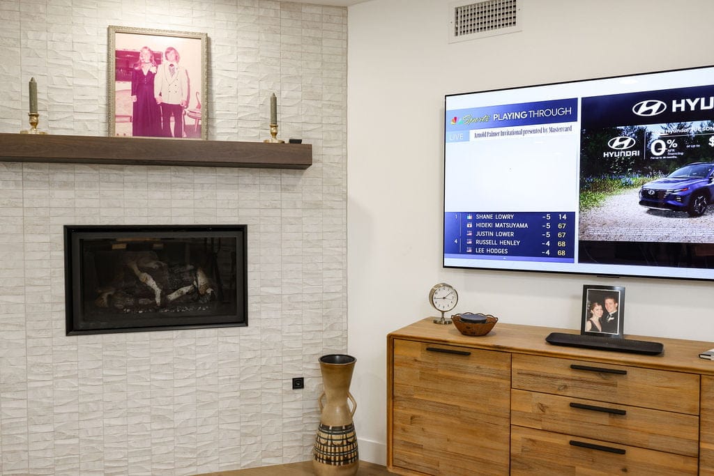 Textured white tile fireplace wall with floating mantel and walnut credenza