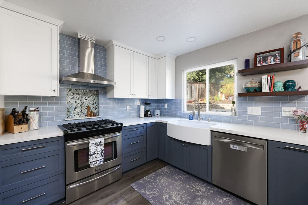 Two-tone kitchen with navy lower cabinets, white uppers and powder-blue subway tile backsplash
