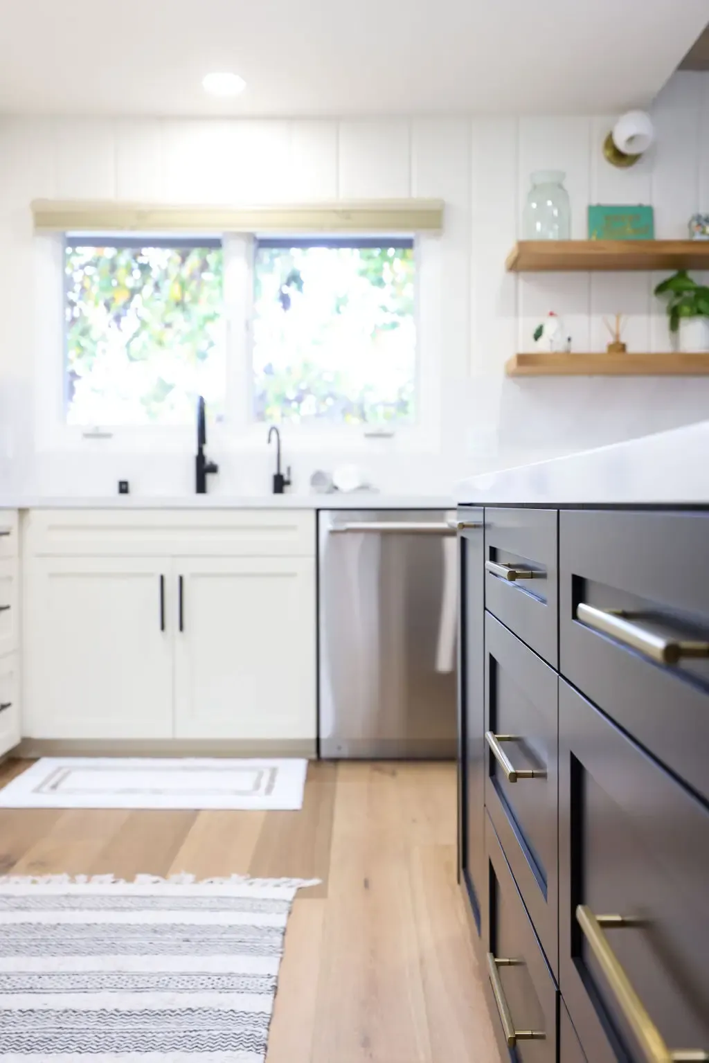 Two-tone kitchen with navy lower cabinets, white uppers and floating wood shelves