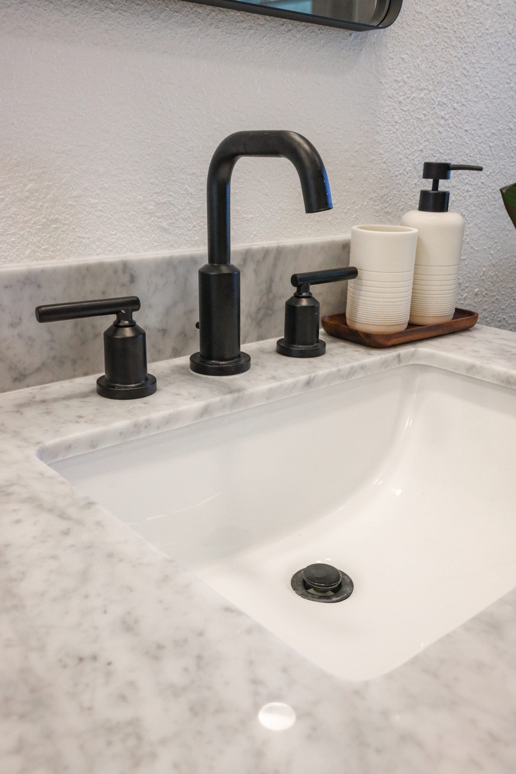 Undermount sink with marble counter, matte black widespread faucet and ceramic accessories