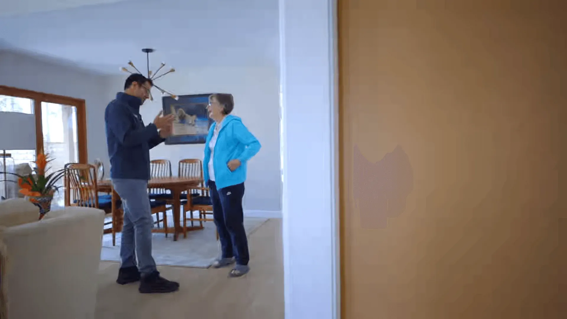 Homeowner greeting contractor in open living and dining room during remodel walkthrough