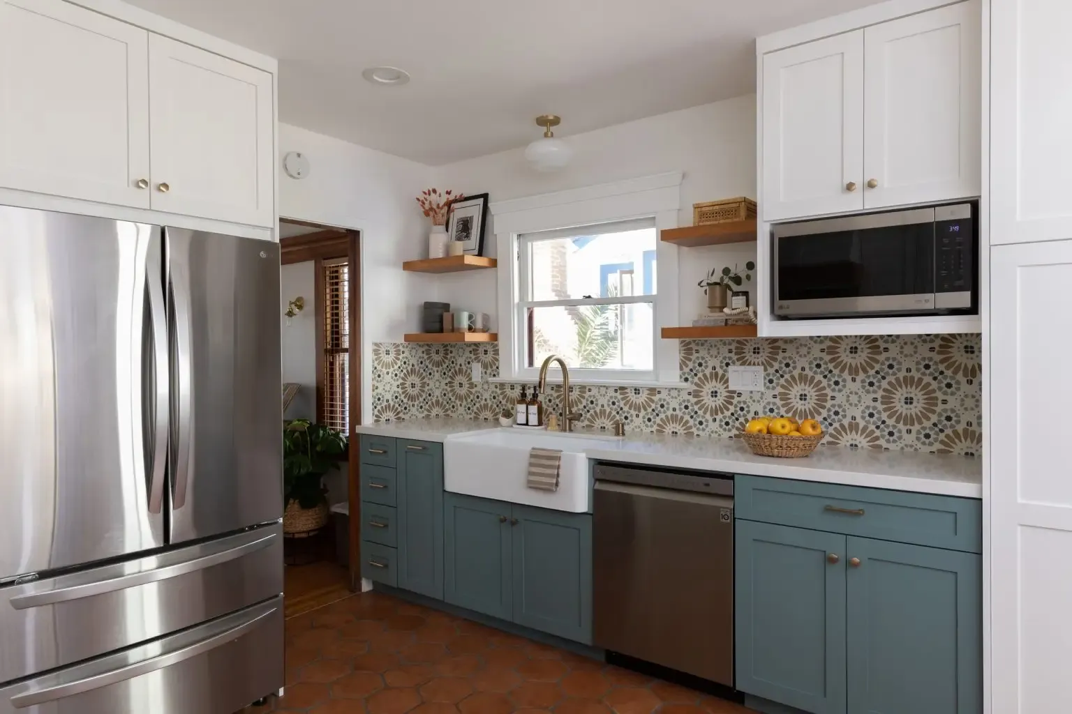 Two-tone kitchen with teal lower cabinets, white uppers, and decorative tile backsplash